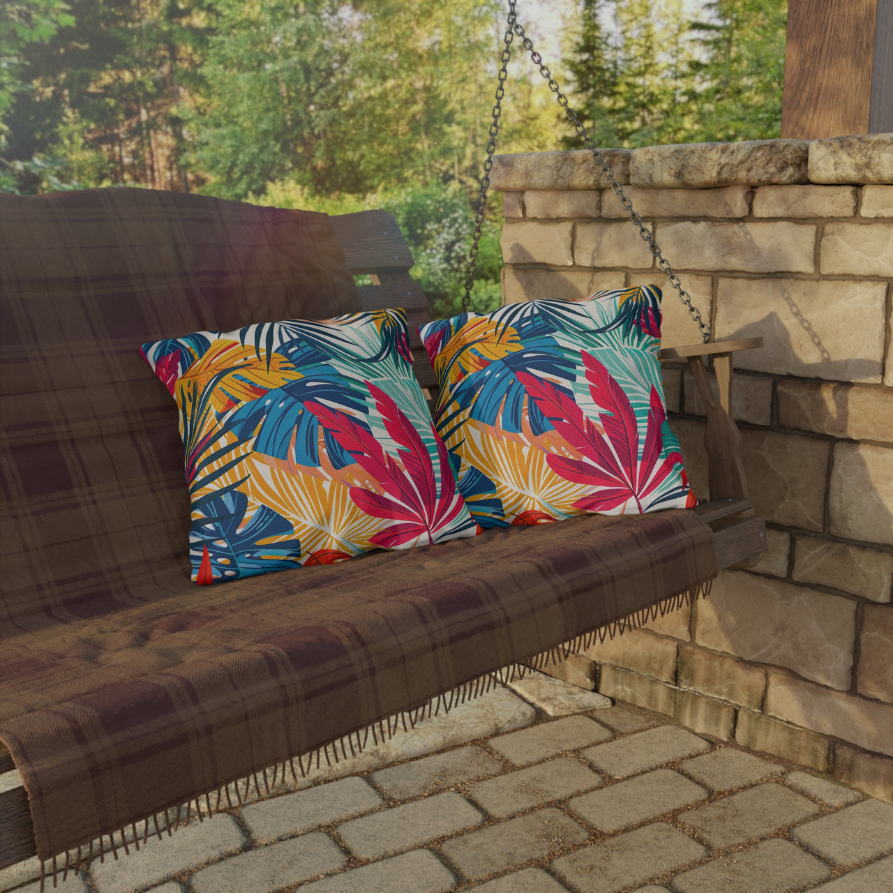 Wooden swing with colorful leaf-patterned cushions on a stone patio.