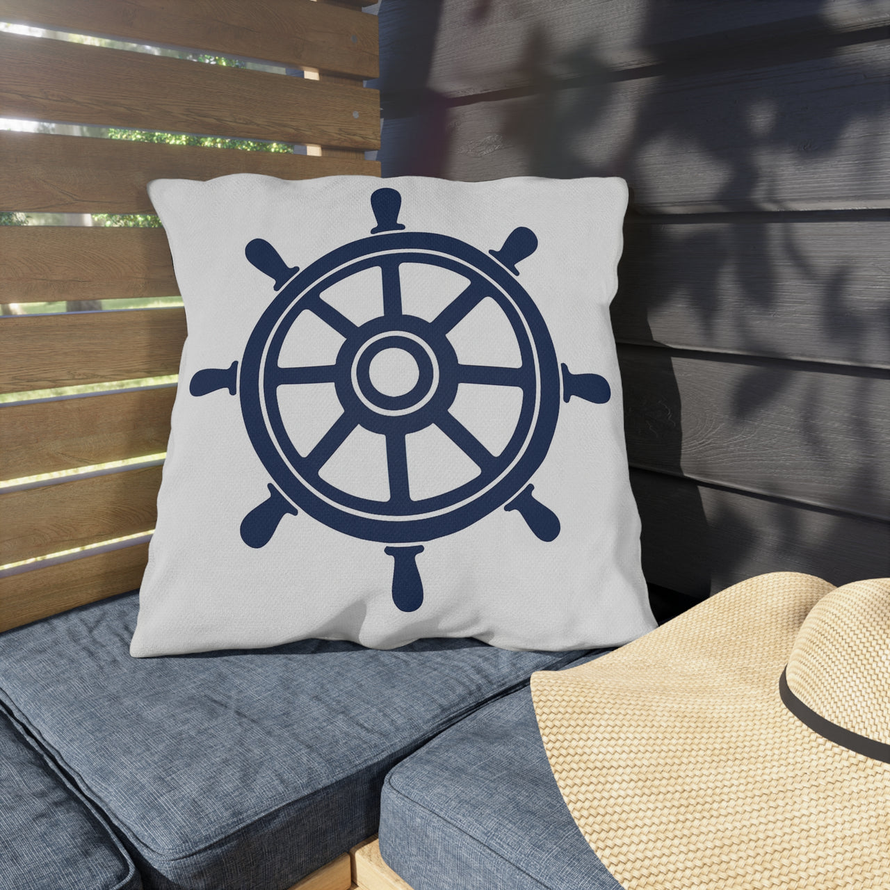 Pillow with a ship's wheel design on a wooden bench