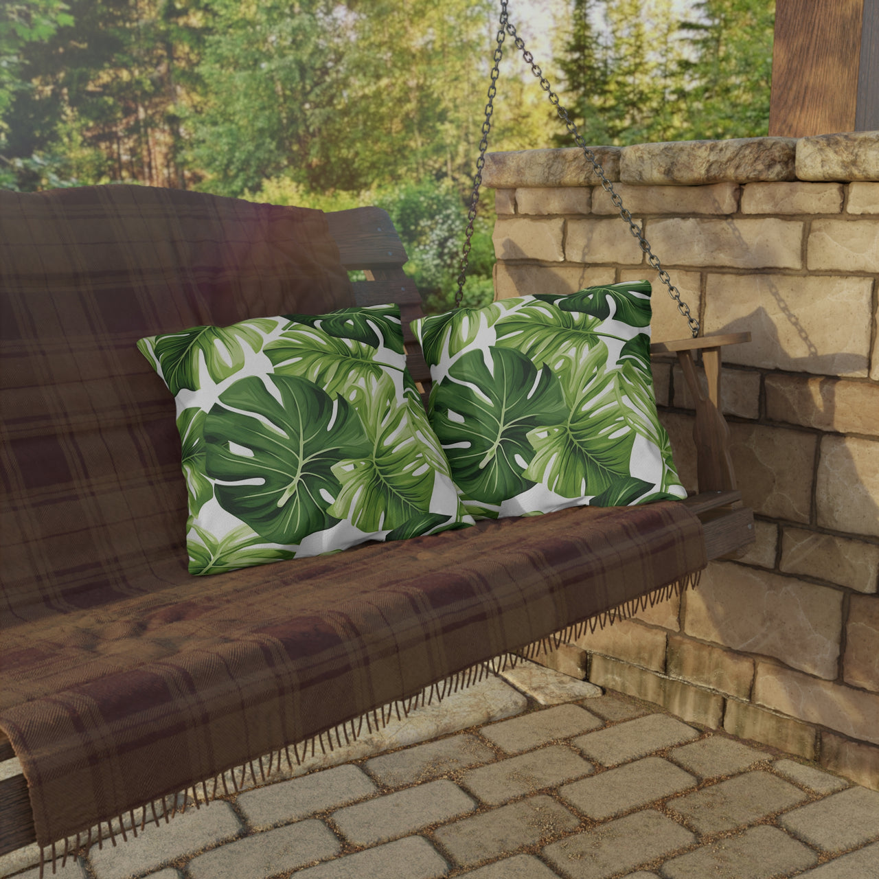 Wooden swing with green leaf-patterned cushions in an outdoor setting.