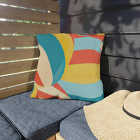 Thumbnail for Colorful geometric pillow on a blue cushioned chair with a straw hat nearby.