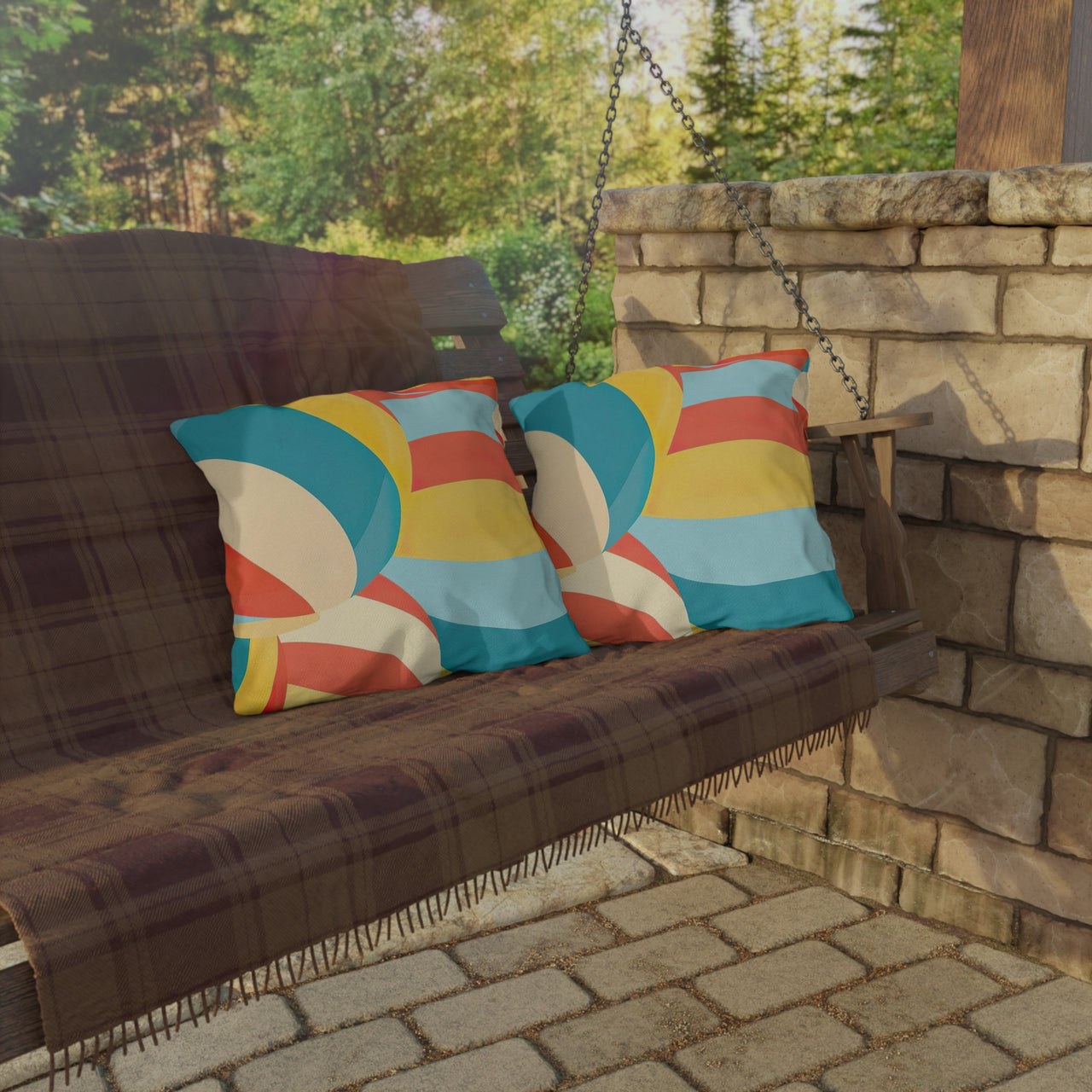 Wooden swing with colorful pillows on a stone patio