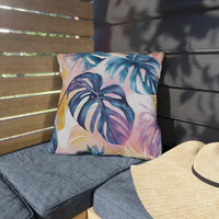 Thumbnail for Tropical leaf patterned pillow on a gray cushioned chair with a straw hat nearby.