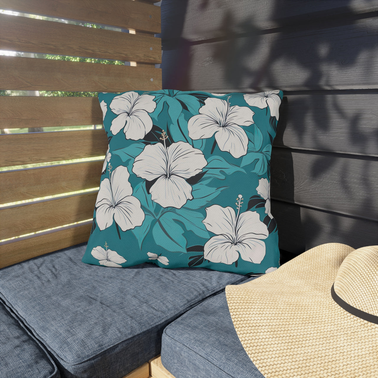 Floral cushion on a bench with a straw hat nearby