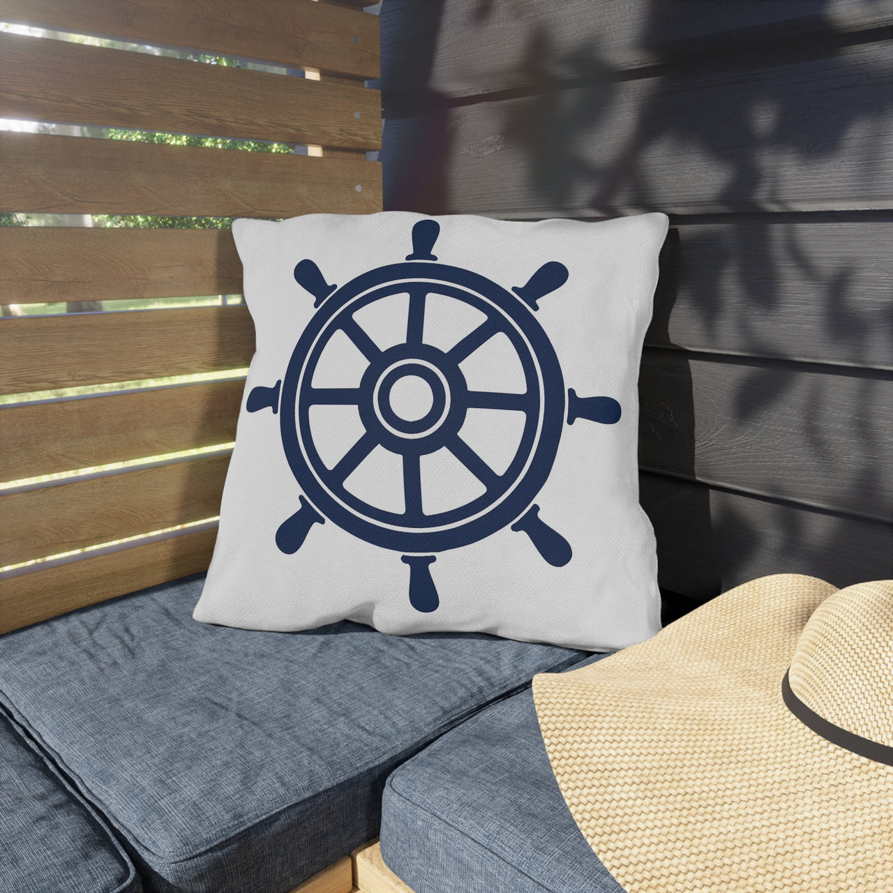 Pillow with a ship's wheel design on a wooden bench