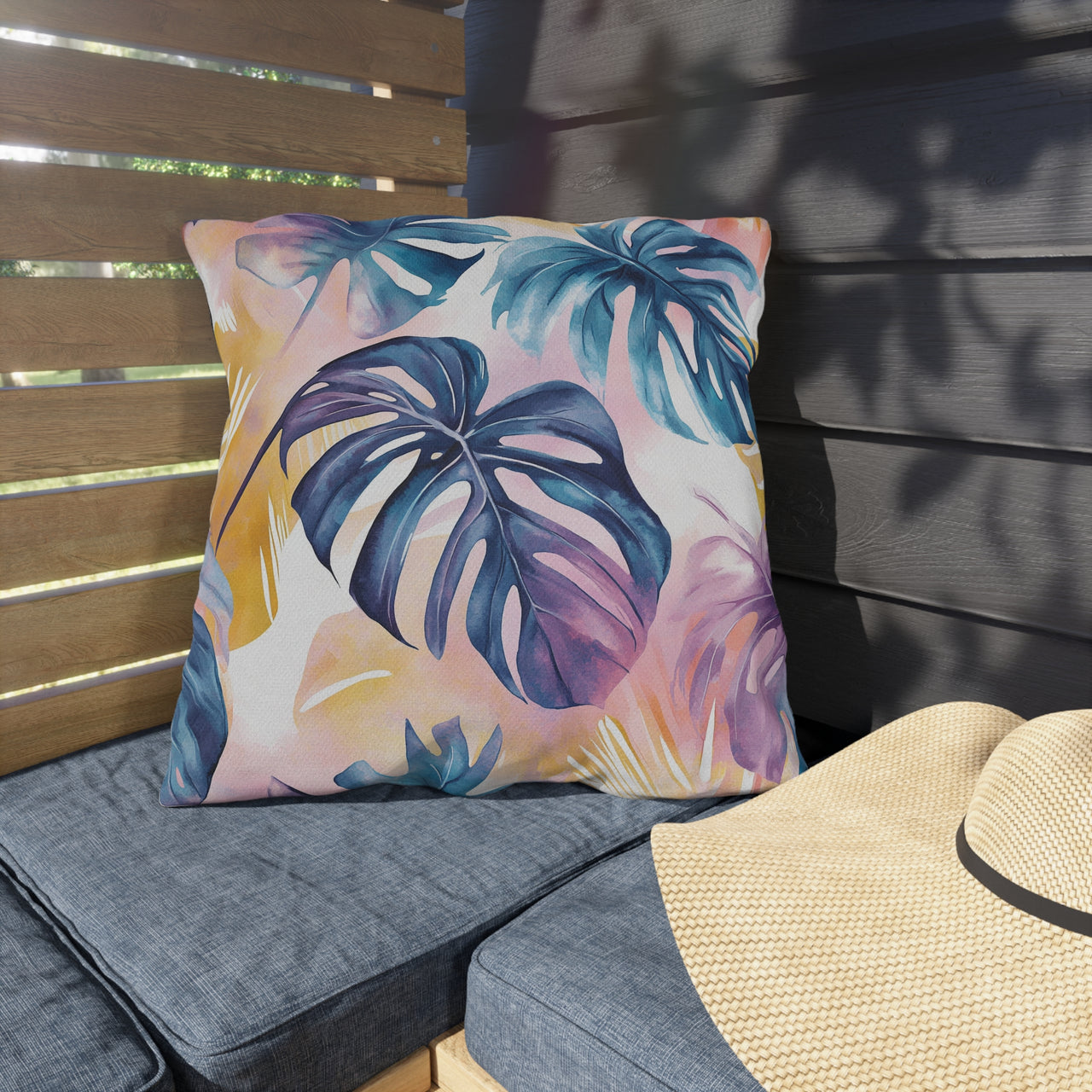 Decorative pillow with tropical leaf pattern on a bench outdoors