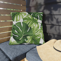 Thumbnail for Green leaf-patterned pillow on a gray cushion with a straw hat beside it on a wooden bench.