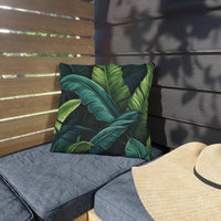 Thumbnail for Outdoor seating area with a green leaf-patterned pillow and a straw hat on a wooden bench.