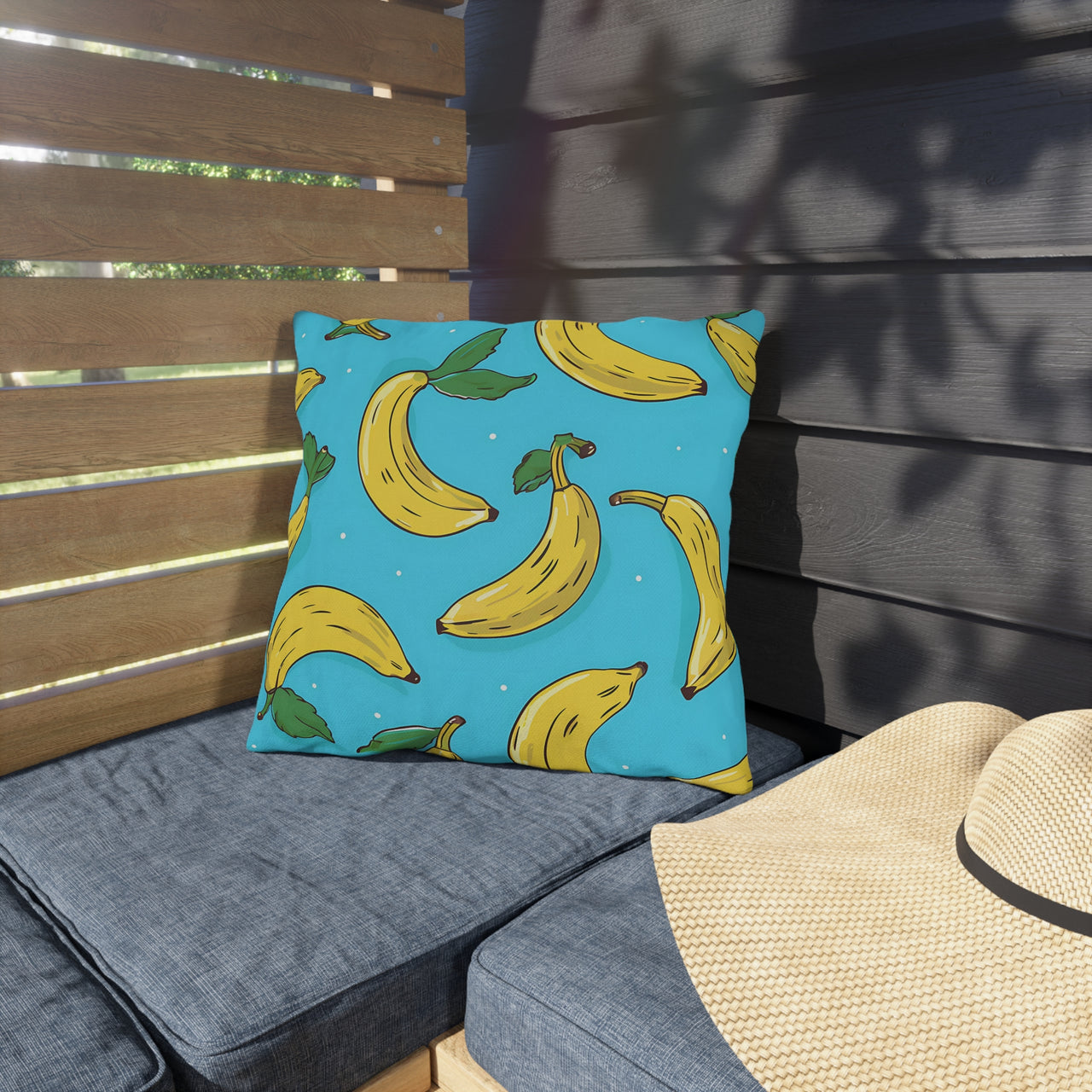 Pillow with banana pattern on a gray cushion outdoors