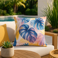 Thumbnail for Decorative pillow with tropical leaf pattern on a patio chair with a pool and plants in the background.
